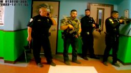 In this video released by Uvalde Mayor Don McLaughlin, Uvalde school police chief Pedro "Pete" Arredondo, left, speaks on his phone in the hallway of Robb Elementary.