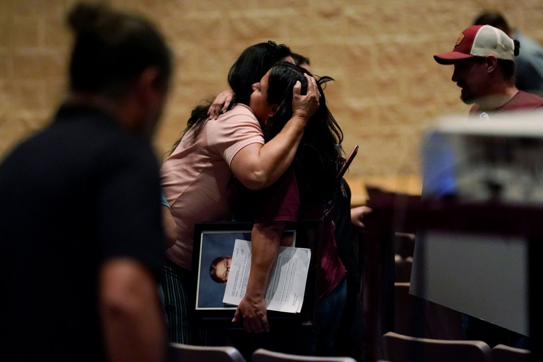 A family member holds a portrait of shooting victim Jackie Cazares as she is hugged following the board meeting in Uvalde on Monday night.