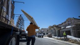 A contractor carries new doors to a home under construction in Antioch, California, US, on Tuesday, June 14, 2022. 