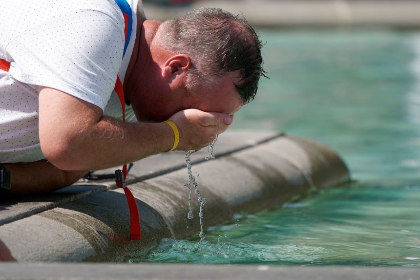 A man refreshes his face at a fountain in Trafalgar Square in central London, Tuesday, July 19, 2022. Britain shattered its record for highest temperature ever registered Tuesday, with a provisional reading of 39.1 degrees Celsius (102.4 degrees Fahrenheit), according to the country's weather office — and the heat was only expected to rise. (Aaron Chown/PA Wire/PA via AP)