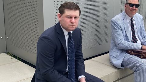 Former Trump White House aide Garrett Ziegler, left, waits Tuesday near a room on Capitol Hill where the January 6 committee conducts its closed-door witness interviews.