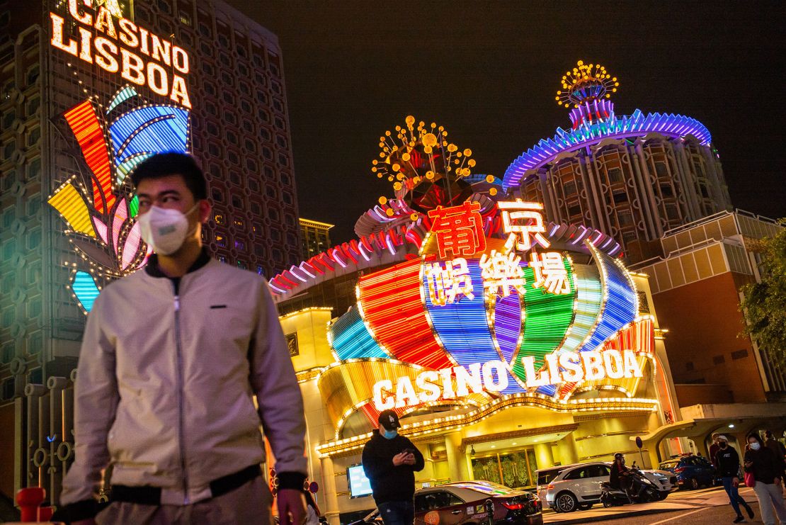 People wearing protective masks walking in front of SJM Holdings' Casino Lisboa in Macao in March 2020. 