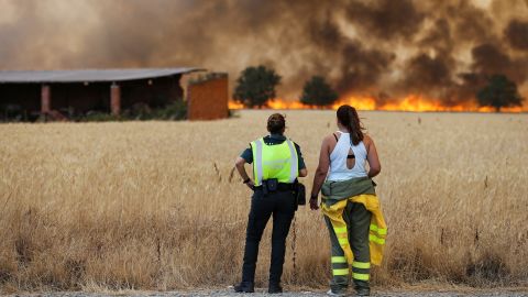 A firefighter and a member of Spain's Civil Guard watch a fire in Zamora, Spain, on July 18.