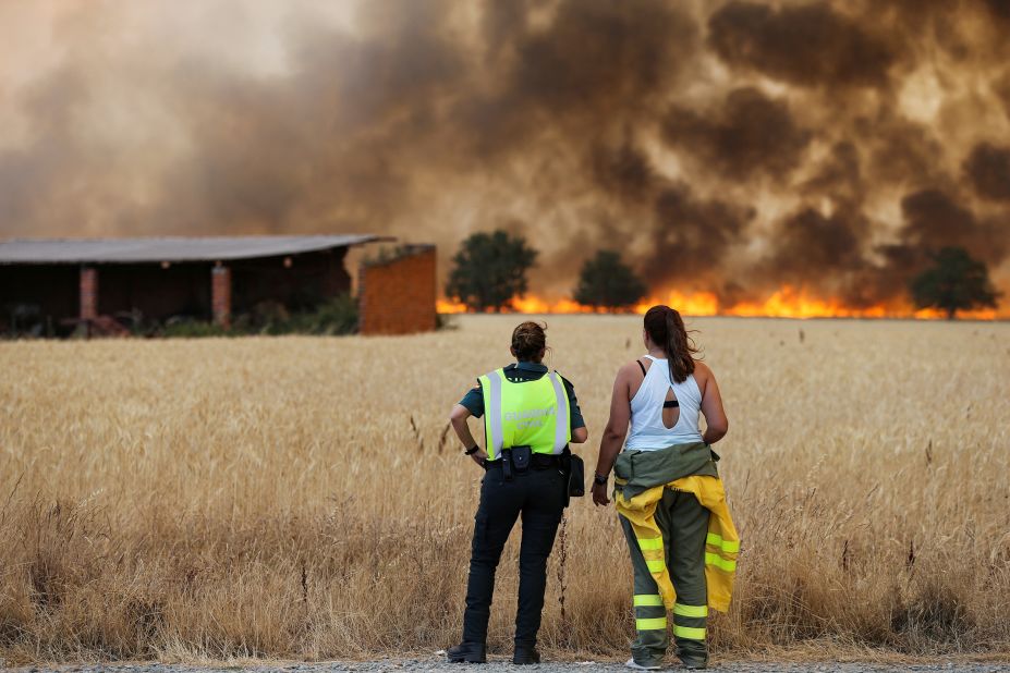 A firefighter and a member of Spain's Civil Guard watch a fire in Zamora, Spain, on July 18.