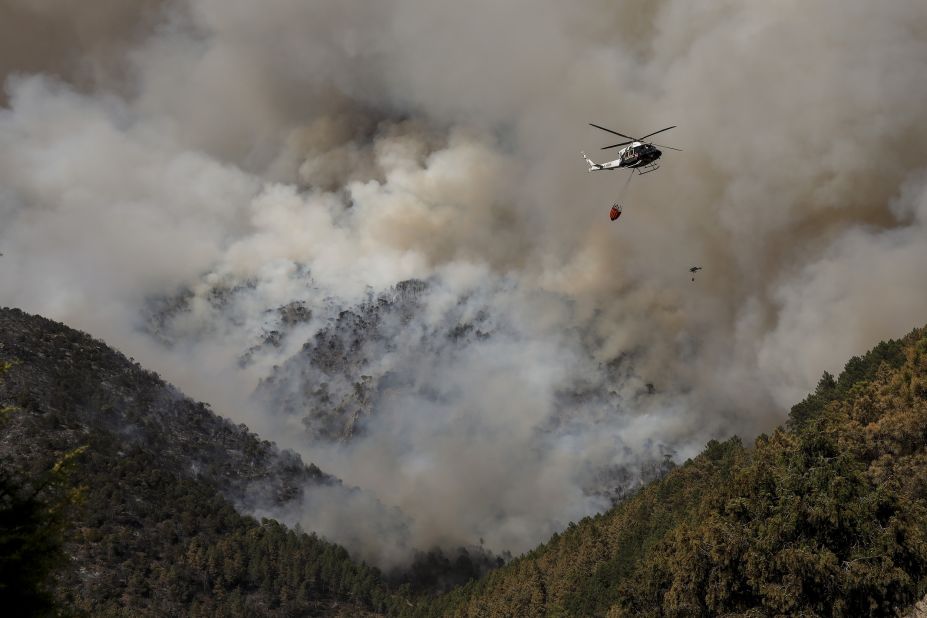 Helicopters drop water above a fire in Avila, Spain, on July 18.