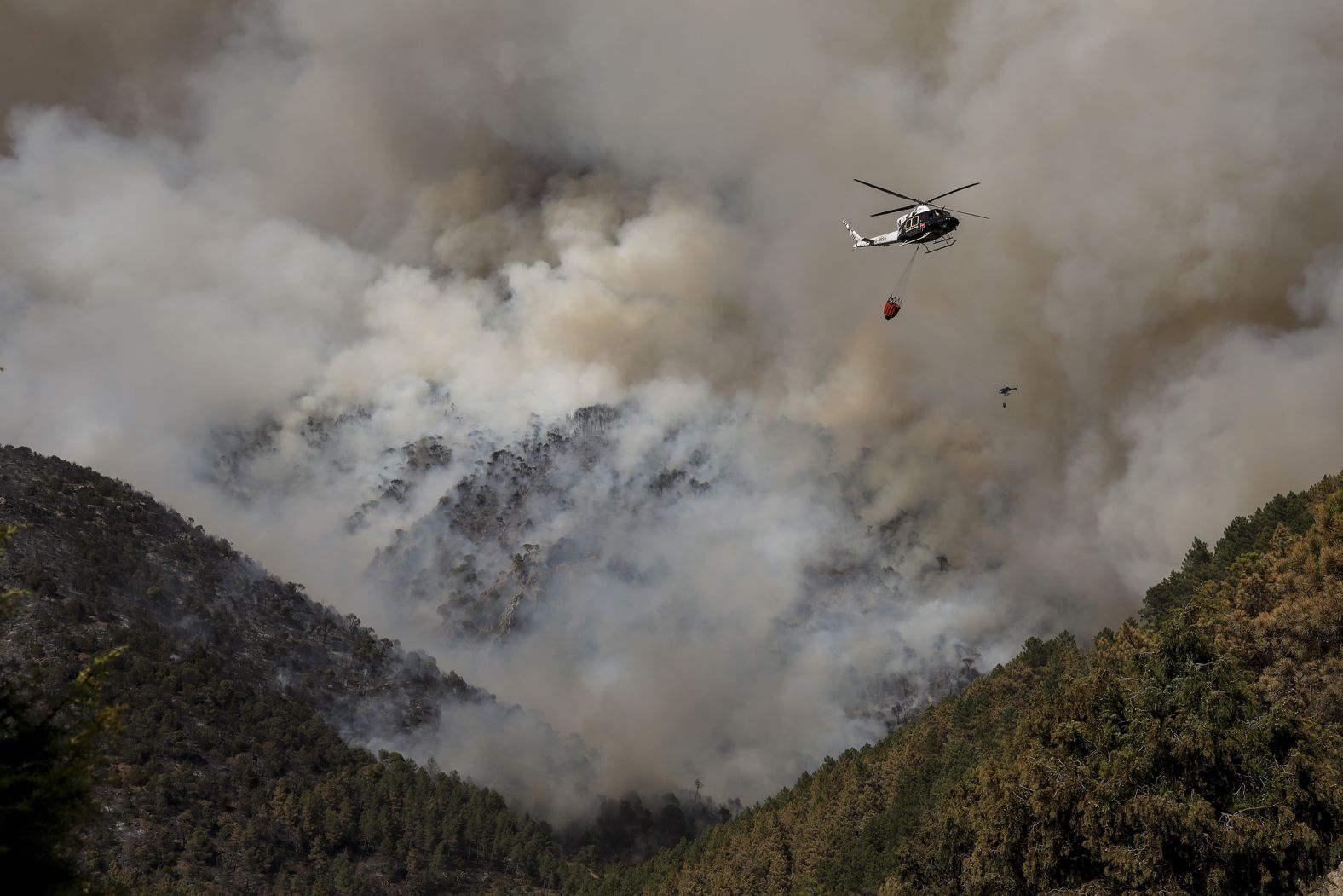 Helicopters drop water above a fire in Avila, Spain, on July 18.