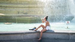 A woman sits by the fountains in Trafalgar Square, central London, as Britons are set to experience the hottest UK day on record as temperatures are predicted to hit 40C. Picture date: Tuesday July 19, 2022. (Photo by Dominic Lipinski/PA Images via Getty Images)