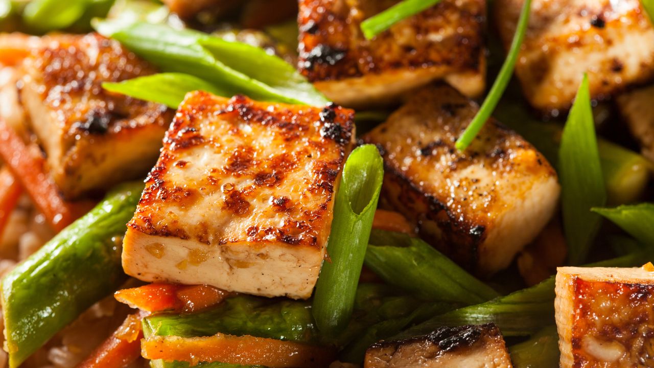 A homemade tofu stir-fry with rice and green vegetables is a crowd pleaser.