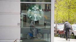 NEW YORK, NEW YORK,  - APRIL 14: A cyclist rides past a closed Starbucks during the coronavirus pandemic on April 14, 2020 in New York City.  (Photo by Rob Kim/Getty Images)