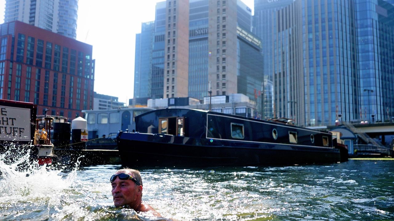 One man takes to the water in the business district of Canary Wharf, east London, Tuesday.