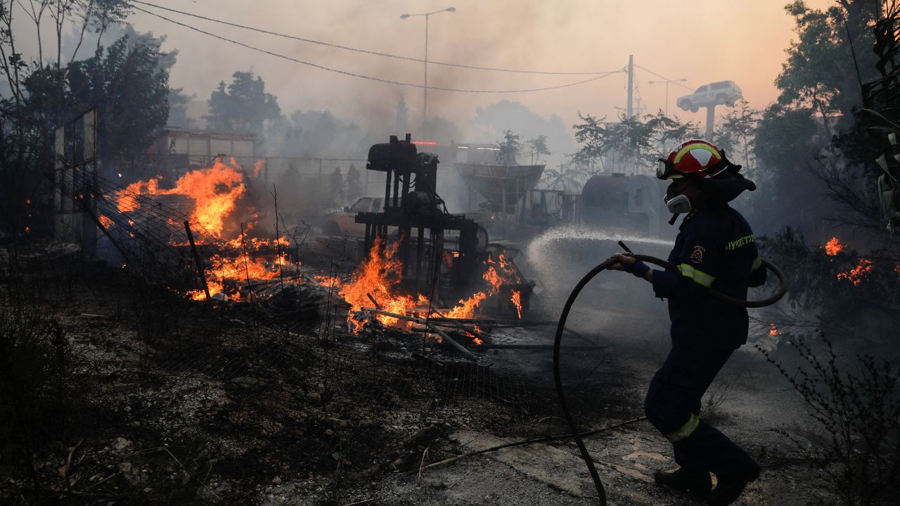 A firefighter tries to extinguish a blaze in Pallini, near Athens, Greece on July 20.
