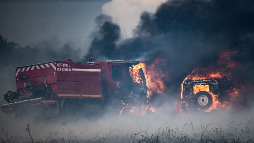 A picture taken on July 19, 2022 shows firefighter trucks burning during a wildfire on the Mont d'Arrees, outside Brasparts, western France. - The fire that broke out on July 18, 2022 at around 2.45pm in Brasparts ravaged 1,700 hectares of moorland in just over 24 hours, far from the more than 19,000 hectares of forest that went up in smoke in Gironde. Up to 260 firefighters and 50 vehicles were mobilised to fight the flames in this natural site known for its biodiversity, in the heart of the Armorique regional nature park. (Photo by LOIC VENANCE / AFP) (Photo by LOIC VENANCE/AFP via Getty Images)