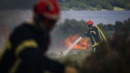 Firefighters spray water on a wildfire raging in the Monts d'Arree, near Brasparts, Brittany, north-western France on July 19, 2022. - A heatwave fuelling ferocious wildfires in Europe pushed temperatures in Britain over 40 degrees Celsius (104 degrees Fahrenheit) for the first time after regional heat records tumbled in France. (Photo by LOIC VENANCE / AFP) (Photo by LOIC VENANCE/AFP via Getty Images)
