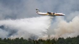 A De Havilland Canada Dash 8-400 MR aircraft drops water over a wildfire raging in the Monts d'Arree, near Brennilis, Brittany, on July 20, 2022. - A heatwave fuelling ferocious wildfires in Europe pushed temperatures in Britain over 40 degrees Celsius (104 degrees Fahrenheit) for the first time after regional heat records tumbled in France. (Photo by LOIC VENANCE / AFP) (Photo by LOIC VENANCE/AFP via Getty Images)