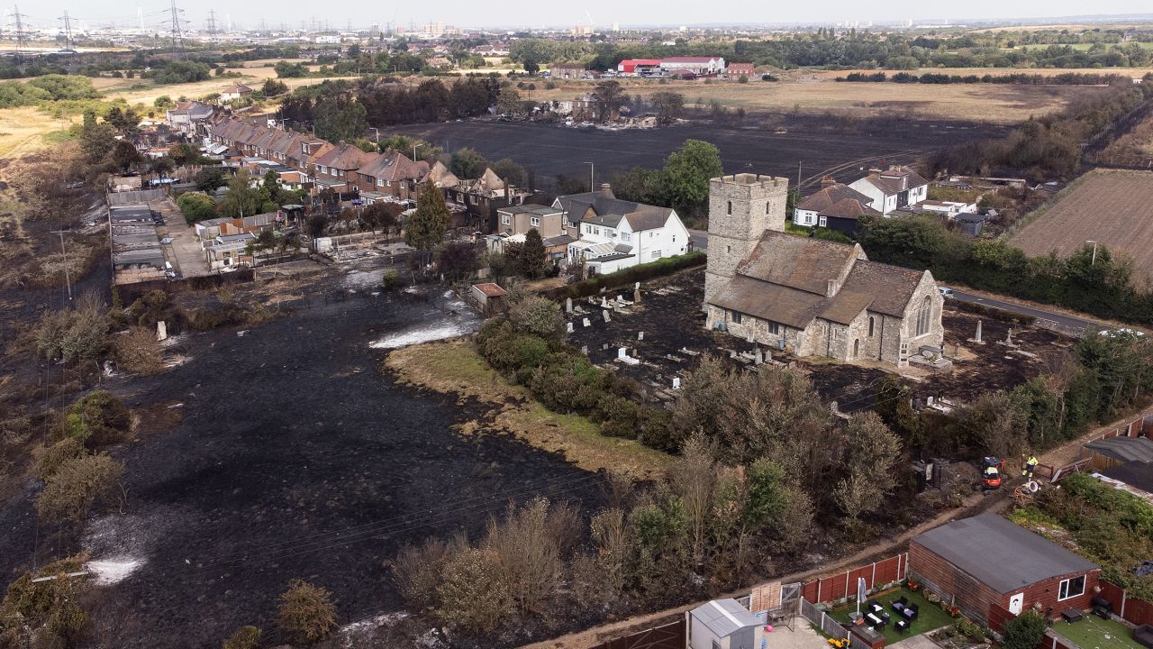 The scorched graveyard around a church following a large blaze in Wennington, east London, on Tuesday. The UK experienced a record-breaking heatwave this week.