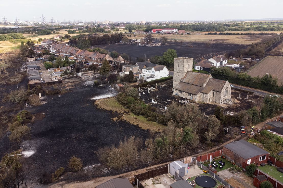 The scorched graveyard around a church following a large blaze in Wennington, east London, on Tuesday. The UK experienced a record-breaking heatwave this week.  