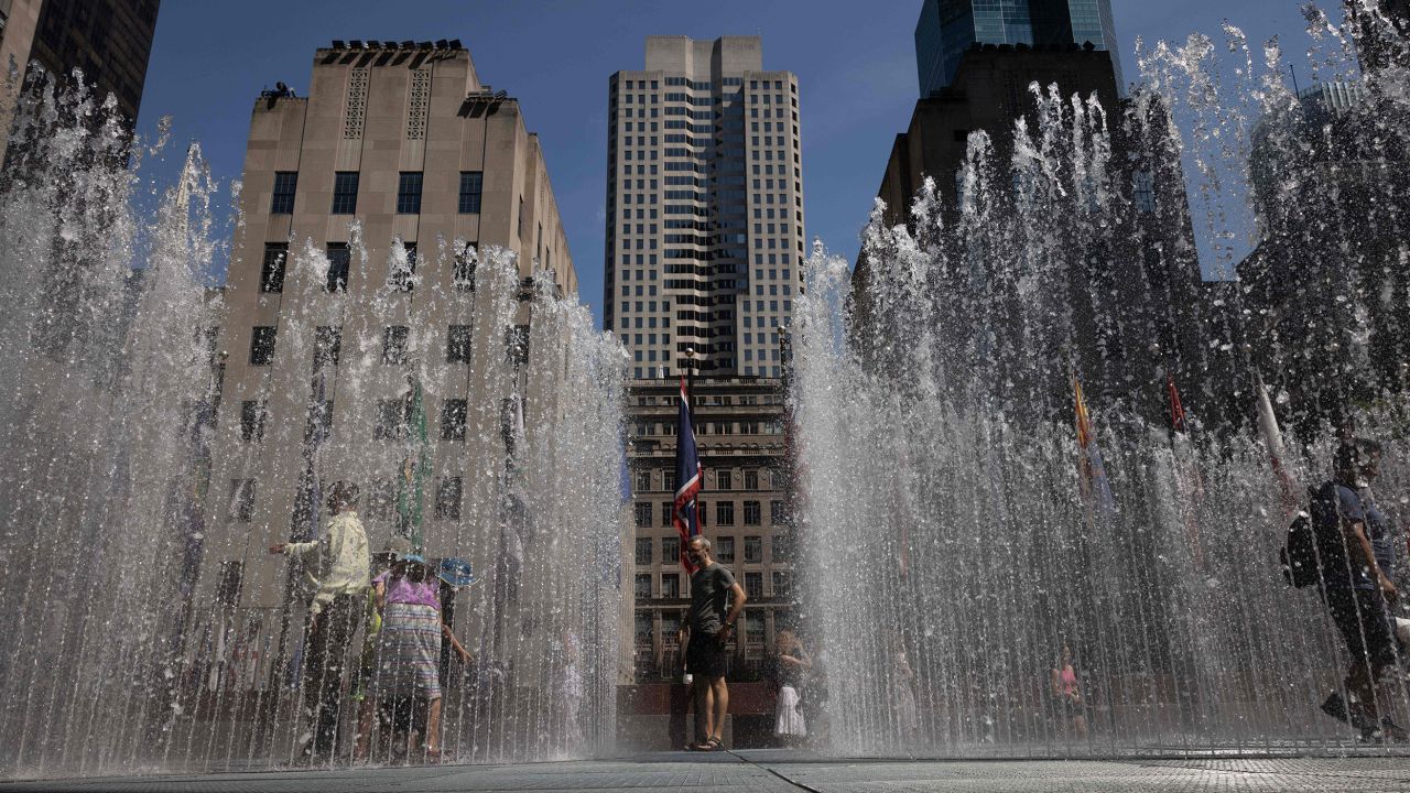 People play in the water sculpture at Rockefeller Center Plaza in New York on Tuesday.