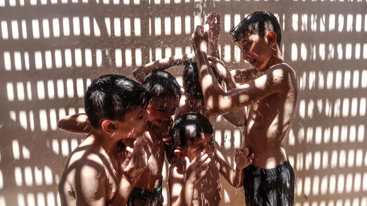 Palestinian children shower to cool off on a hot summer day in Gaza City on July 20. 
