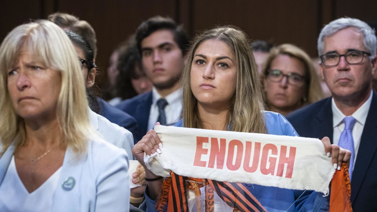 An attendees holds an "Enough" sign during a Senate Judiciary Committee hearing in Washington, DC, on Wednesday, July 20, 2022. Democrats are pushing to limit access to assault weapons on two fronts amid unrelenting mass shootings, which party leaders say now claim the lives of almost a dozen people every week. 
