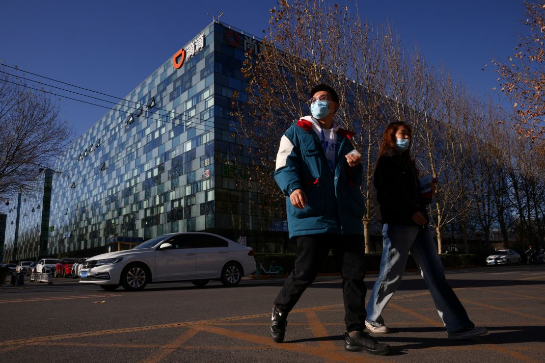 People walk past the headquarters of the Chinese ride-hailing service Didi in Beijing, China, December 3, 2021. 