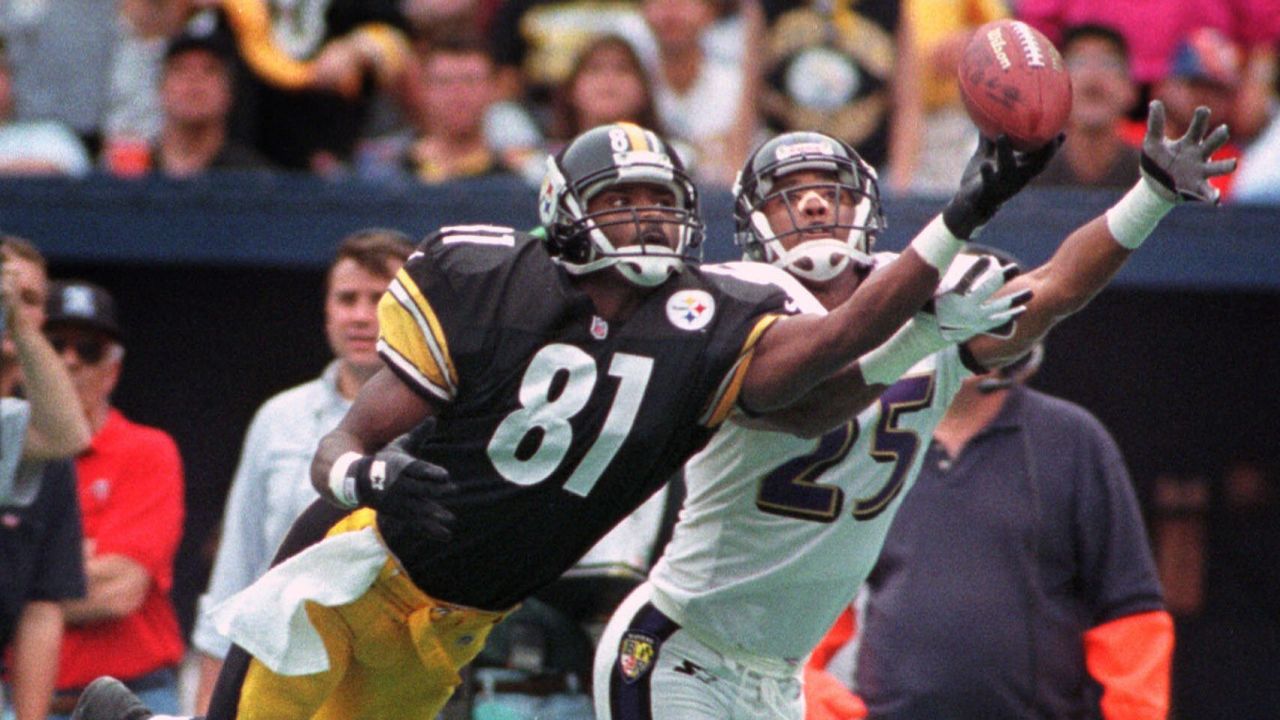 Johnson dives for a pass as the Baltimore Ravens' DeRon Jenkins defends him during a game on October 18, 1998.