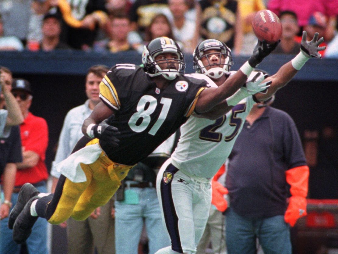 Johnson dives for a pass as the Baltimore Ravens' DeRon Jenkins defends him during a game on October 18, 1998.