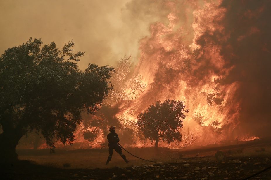 A firefighter battles a blaze in the suburb of Pallini, east of Athens, Greece, on July 20.