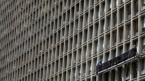 Window washers work on a building with rows of air conditioners in New York City in April of last year. 