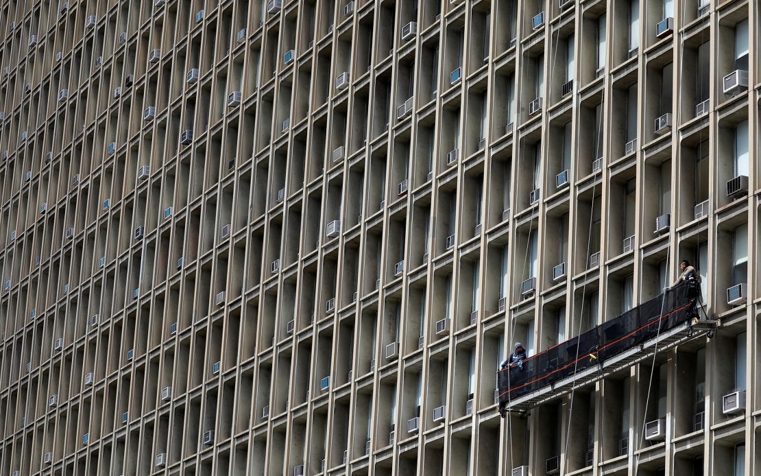 Window washers work on a building featuring rows of air conditioners in New York City, in April last year. 