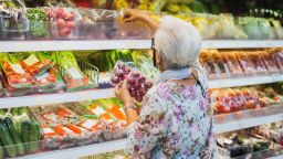 Senior woman wearing protective mask doing grocery shopping in supermarket