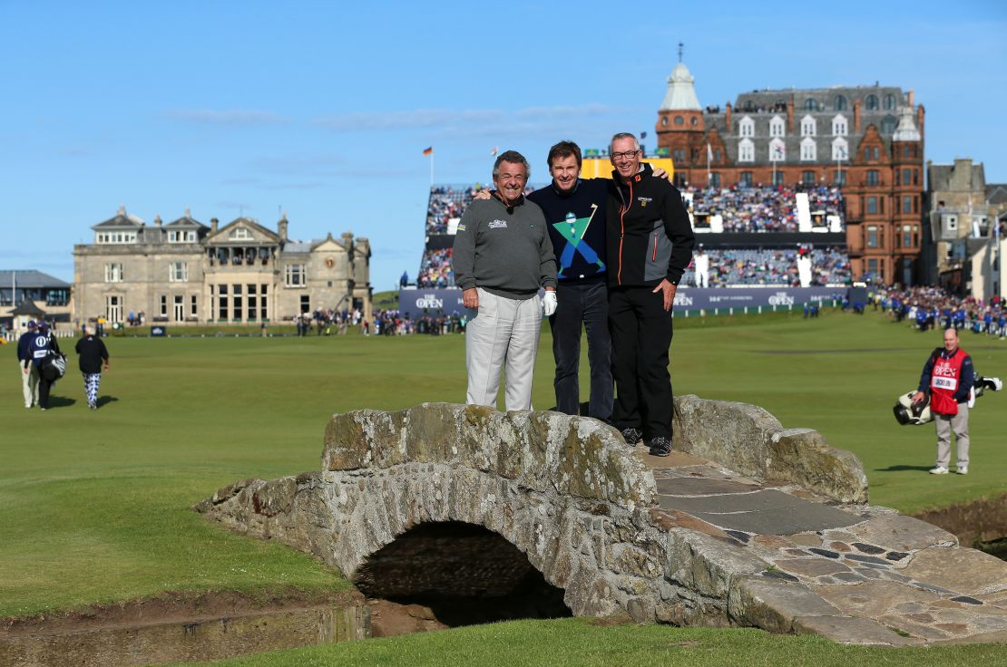 (L-R) English golfers Tony Jacklin and Nick Faldo pose with Cannon on the Swilcan Bridge ahead of the 144th Open Championship at St Andrews, Scotland in 2015.