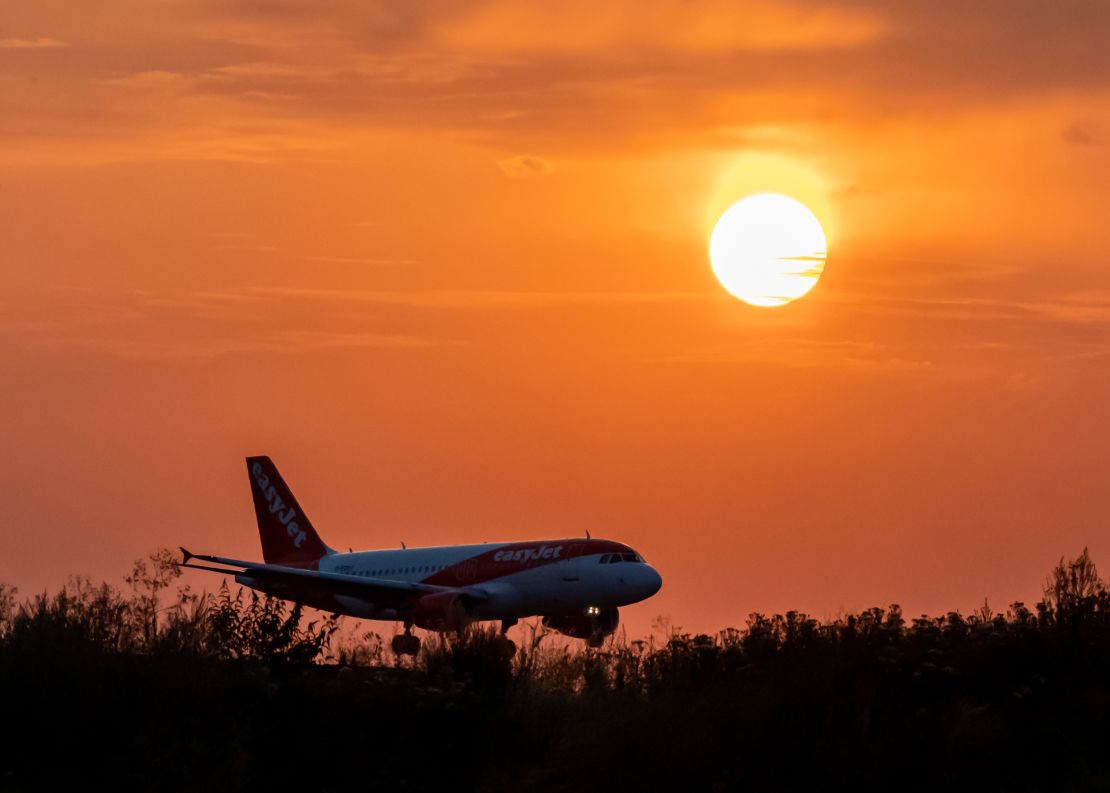 An Easy Jet plane lands during sunset at Luton Airport after a small section of the runway had lifted due to high temperatures on July 18, 2022.