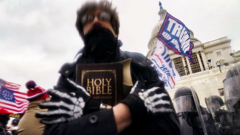 A Trump supporter holds a Bible as he gathers with others outside the US Capitol on January 6, 2021.