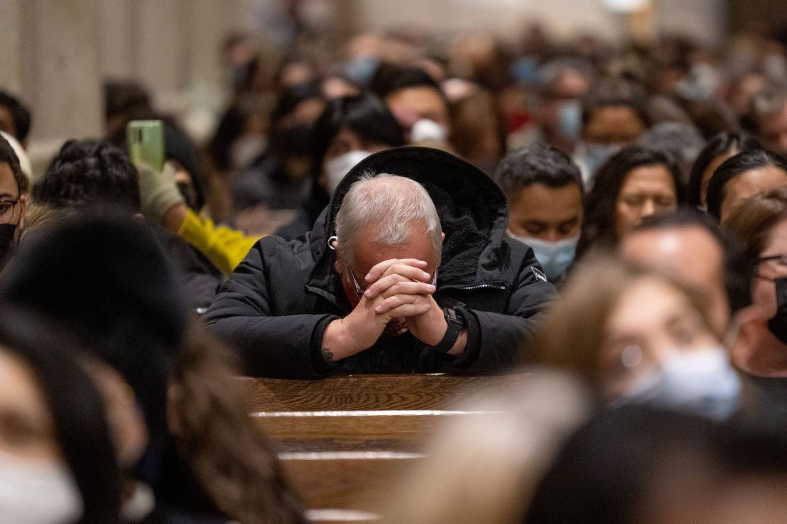 A parishioner bows his head to pray while celebrating midnight Mass at St. Patrick's Cathedral on December 24, 2021, in New York City.