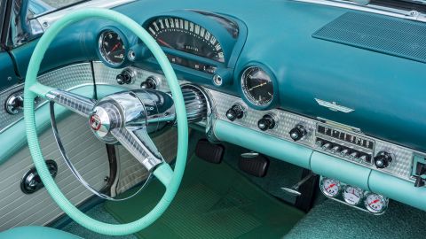 Vintage 1955 Ford Thunderbird interior showing steering wheel and dashboard in teal and aqua colors. (Photo by: Arterra/Universal Images Group via Getty Images)