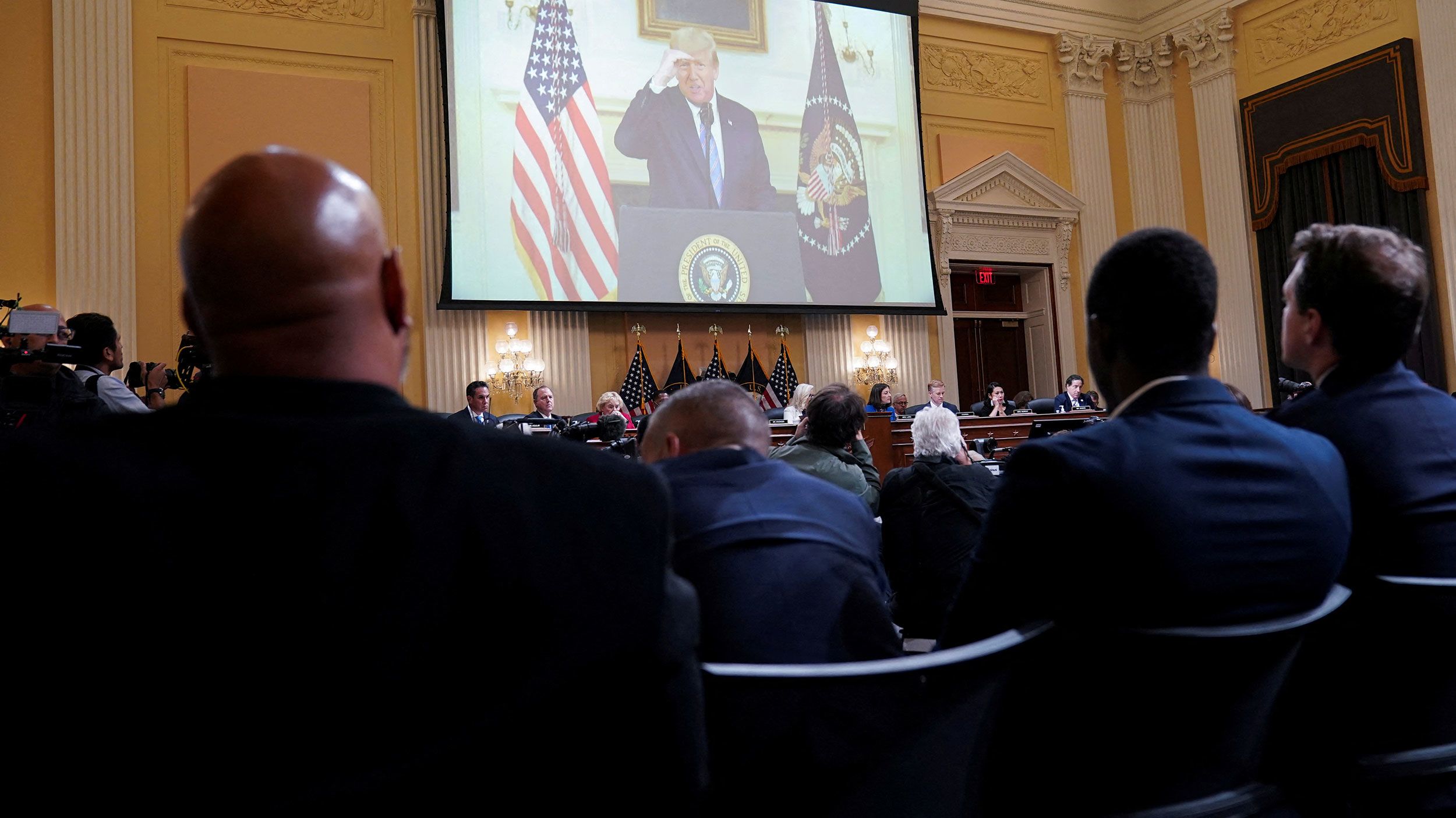 Previously unseen footage of then-President Trump rehearsing a video message is shown over the committee during its public hearing on July 21. <a href="index.php?page=&url=https%3A%2F%2Fwww.cnn.com%2Fpolitics%2Flive-news%2Fjanuary-6-hearings-july-21%2Fh_742b695f5e6532ac2d04a7323a4c6955" target="_blank">During outtakes of the message,</a> recorded on January 7, 2021, Trump struggled to condemn the violence at the US Capitol and refused to say "the election is over."