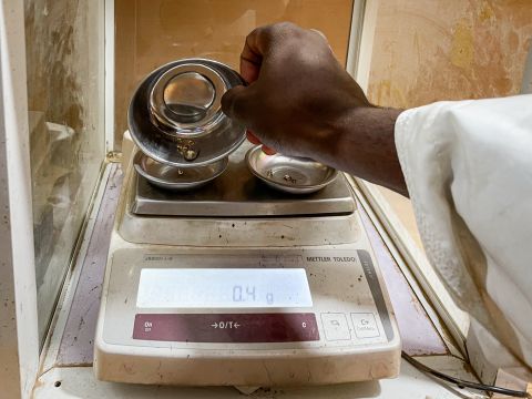 Gold flakes being weighed at a gold lab.