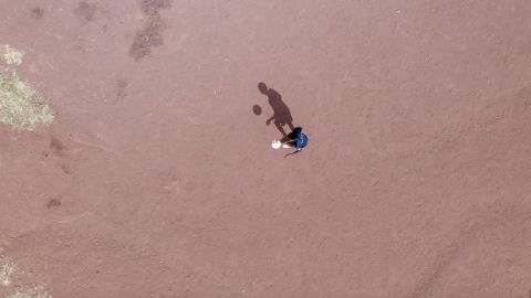 Mutunkei practices his football skills on a barren patch of land.