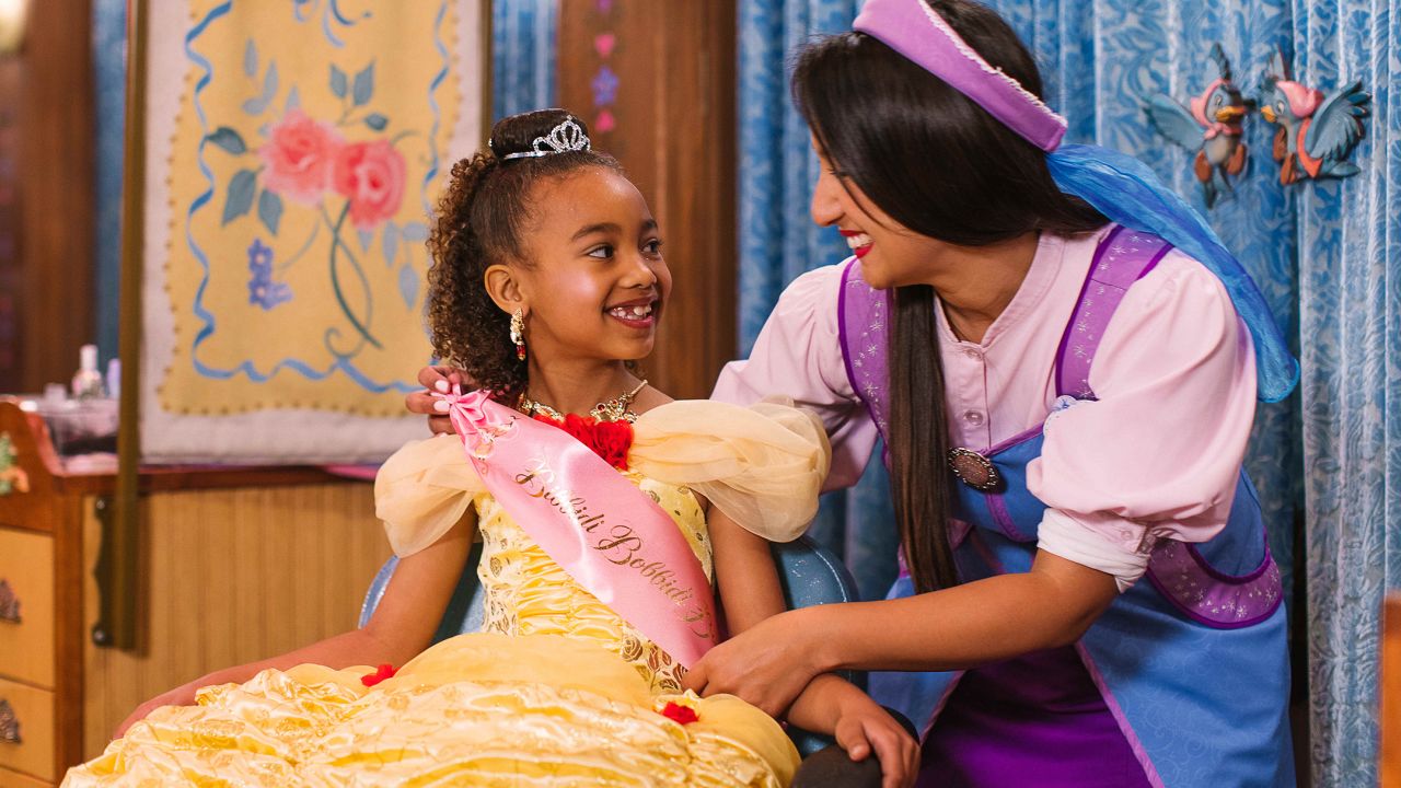 A child is outfitted by an employee at Disney's Bibbidi Bobbidi Boutique at Disneyland in Anaheim, California.