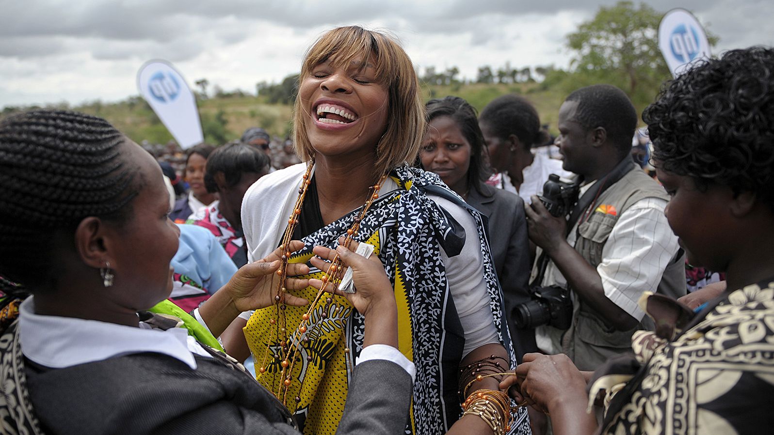 Williams laughs as women from the Kamba tribe dress her in traditional regalia to inaugurate a school she funded in Kenya's Wee village in 2010.