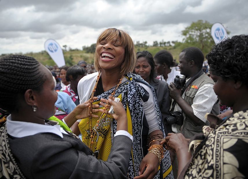 Williams laughs as women from the Kamba tribe dress her in traditional regalia to inaugurate a school she funded in Kenya's Wee village in 2010.