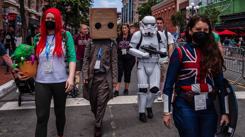 People dressed in costumes walk near the San Diego Convention Center.