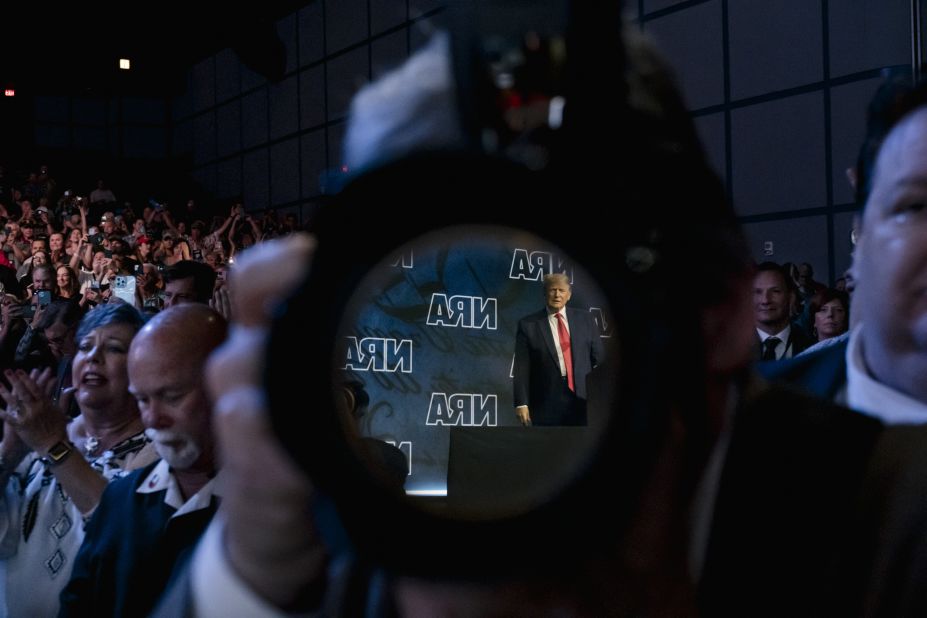 Trump is seen in the reflection of a camera lens as he appears at the National Rifle Association's annual convention in May 2022. Trump — and other GOP leaders who spoke at the event in Houston — <a href=