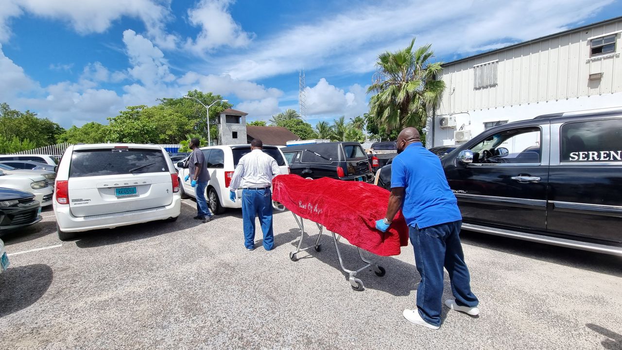 The body of one of those who died is taken away by mortuary workers in Nassau.