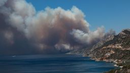 TOPSHOT - The smoke of a wildfire billows as it approaches Vatera coastal resort on the eastern island of Lesbos on July 23, 2022. - Residents were evacuated as the wilfire threatened properties. (Photo by Manolis LAGOUTARIS / AFP) (Photo by MANOLIS LAGOUTARIS/AFP via Getty Images)