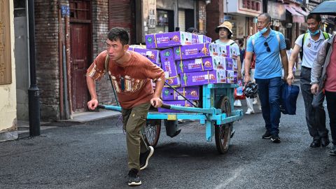 A man hauls a cart loaded with coconuts at Gulangyu Island in Xiamen, Fujian province on July 24, 2022.