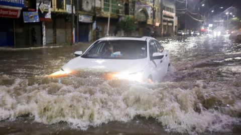 A vehicle drives along a flooded street following heavy rains during the monsoon season in Karachi, Pakistan July 24, 2022.