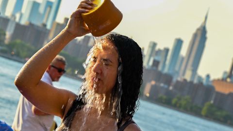 A woman pours water on her face in New York City as temperatures soared into the upper 90s on Sunday.