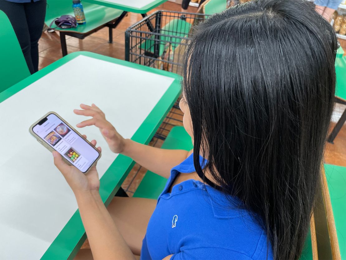 Lily Yu of Riverside, California, shows the Flashfood app, which displays grocery items close to their sell-by dates.