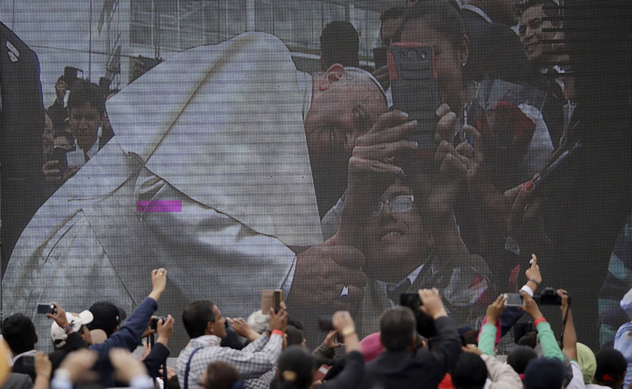 People in Quito, Ecuador, gather near a huge video screen broadcasting the Pope's visit to the city in July 2015.